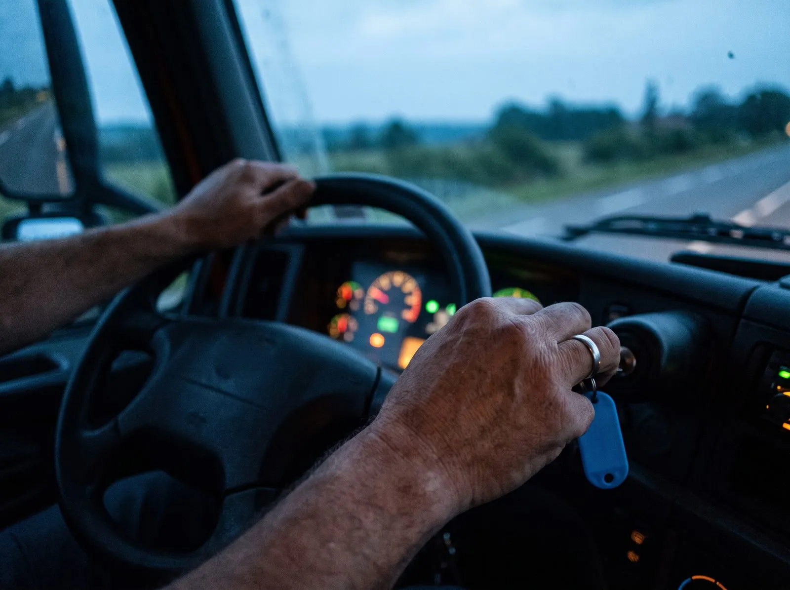 Avant l’aube, la main d’un chauffeur sur la clé de contact d’un camion