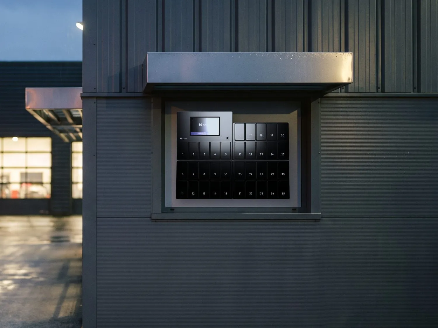 Casier connecté kazeo en métal noir fixé sous un auvent, sur la façade extérieure d’un bâtiment