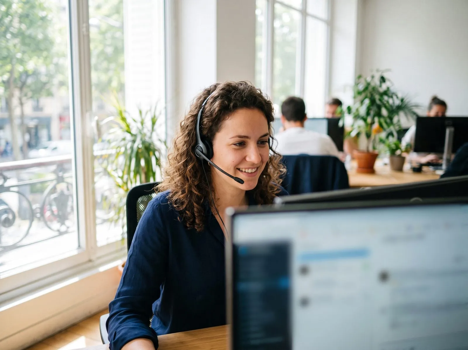 Une conseillère de l’assistance, casque sur les oreilles, répond à un appel devant son ordinateur