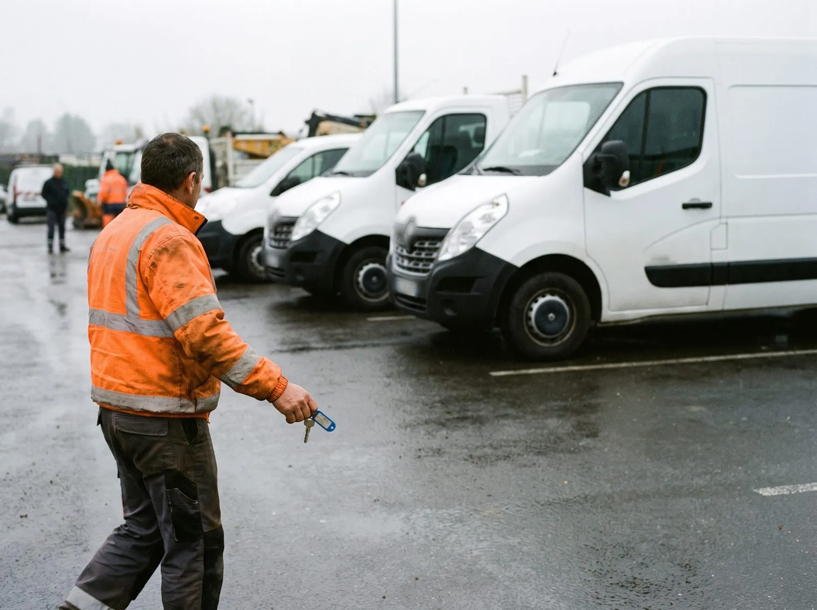 Tôt le matin dans un centre technique municipal, un agent en gilet orange rejoint les fourgons, la clé à la main